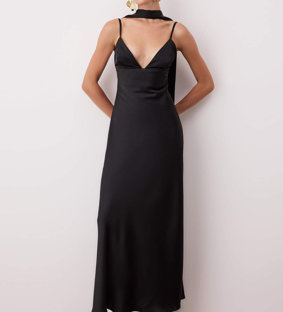  Woman wearing a black satin deep V-neck slip dress with scarf detail — AtikaStyle.”
