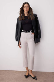 Woman wearing Atikastyle slim-fit beige tailored trousers – high waist ankle-length pants styled with black top and flats.”
