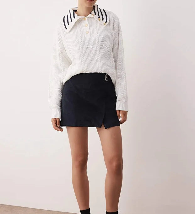 Classic meets modern: this white knit sweater features gold button details and a chic navy-striped collar. A timeless pullover for cozy days and elevated outfits.
