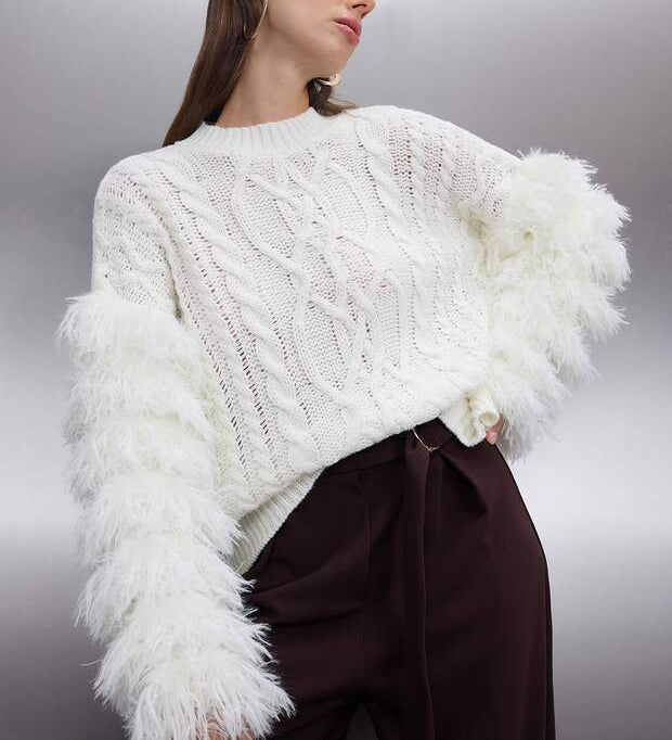 	•	White cable knit sweater with feather sleeves – AtikaStyle
	•	Statement knit sweater with dramatic white feather sleeves – AtikaStyle
	•	Chic white sweater styled with trousers – AtikaStyle
