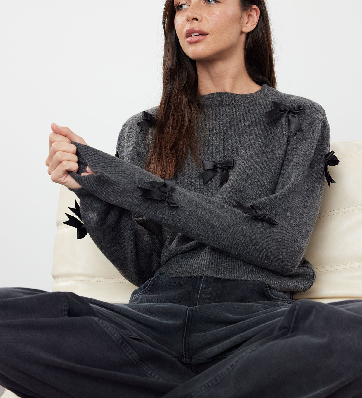 Discover a touch of elegance with our charcoal sweater adorned with chic black bows. Perfect for any casual or semi-formal occasion, this cozy sweater brings feminine charm to your wardrobe.