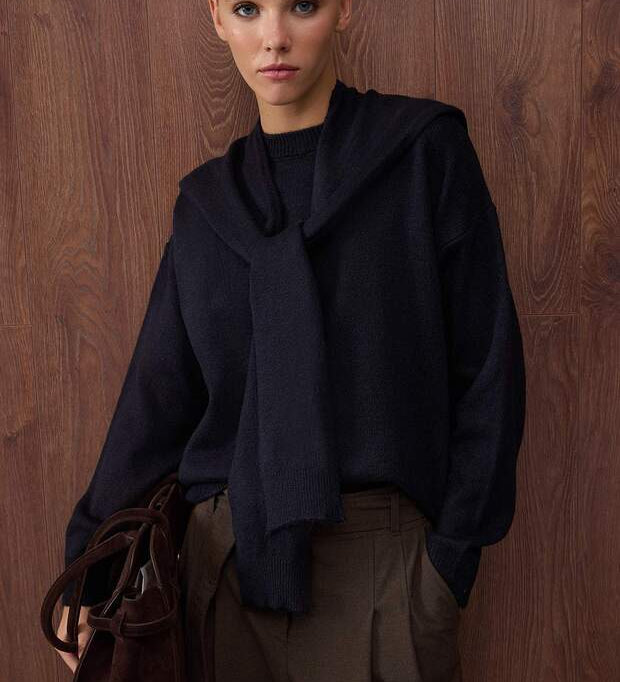 •	Black knit sweater with tie detail front view – AtikaStyle
	•	Cozy black pullover sweater with scarf-style tie – AtikaStyle
	•	Minimalist black knit sweater styled for everyday wear – AtikaStyle
