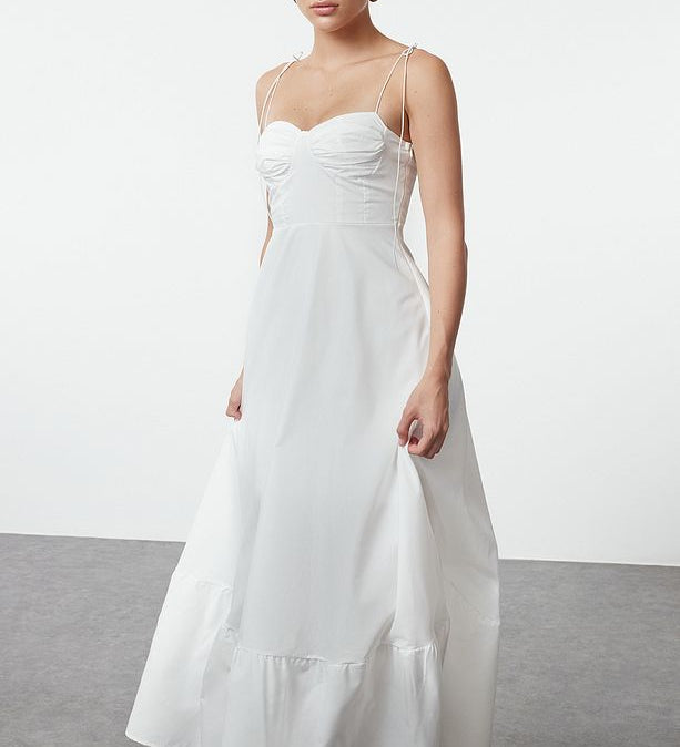 Woman wearing Atikastyle white bustier maxi slip dress with spaghetti straps – elegant long gown for women.”
