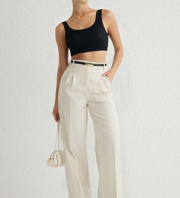 Woman wearing Atikastyle high-waisted beige wide-leg trousers with pleated front – elegant tailored workwear pants for women.”
