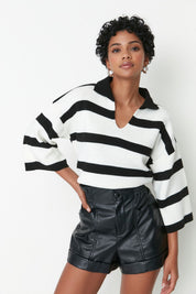 Woman wearing Atikastyle black and white striped knit polo sweater with deep V-neckline – casual chic long sleeve top.”

