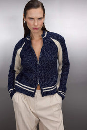 Woman wearing a navy and cream contrast knit zip-up sweater with ribbed sleeves and stripe hem – AtikaStyle.”

