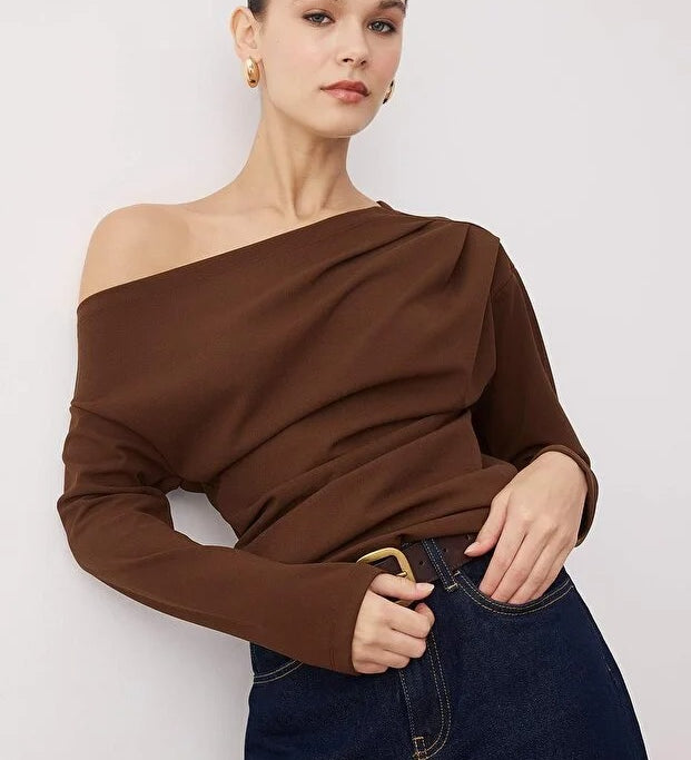 Woman wearing a chocolate brown off-shoulder long-sleeve top paired with dark denim — AtikaStyle.”
