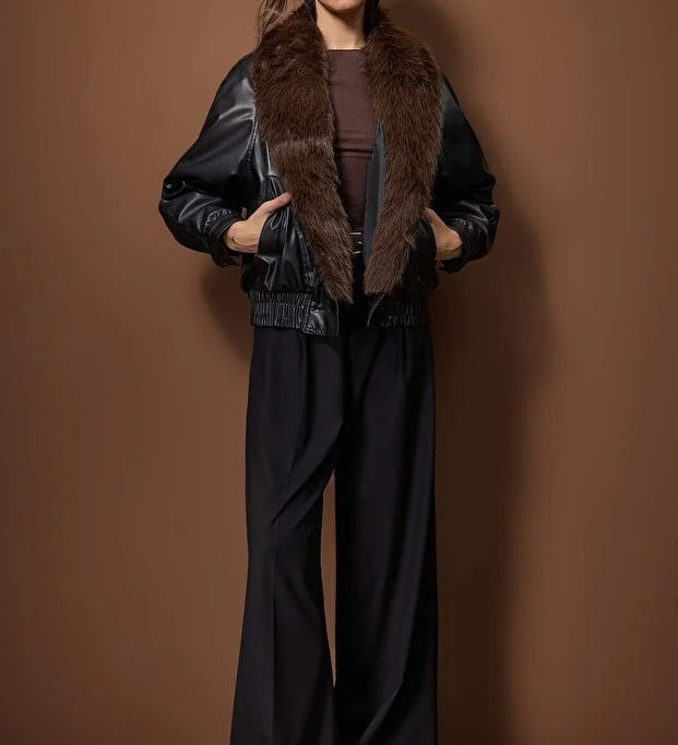 
Woman wearing a black faux leather bomber jacket with a brown faux fur collar, stylish winter outerwear – AtikaStyle.
