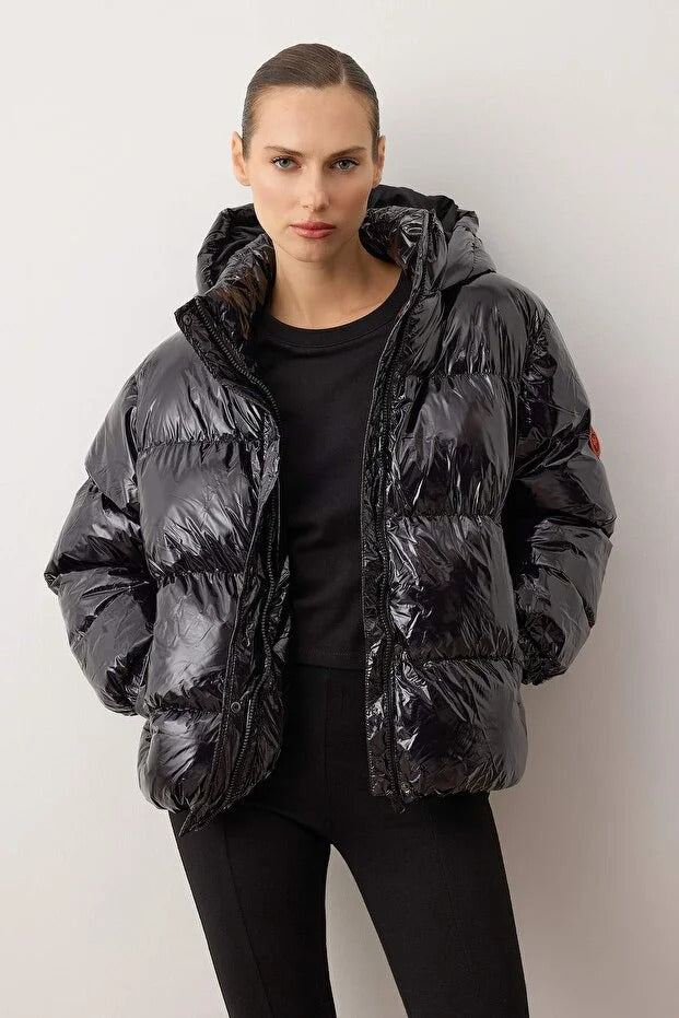 Person wearing a black puffer jacket against a white background