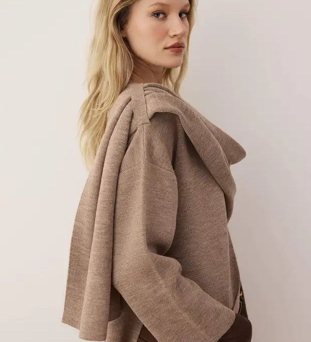 Woman wearing a brown coat against a plain background