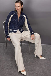 Woman wearing a navy and cream contrast knit zip-up sweater with ribbed sleeves and stripe hem – AtikaStyle.
