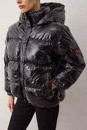 Black puffer jacket worn by a person on a plain background