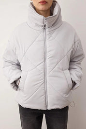Light gray quilted jacket worn by a person on a plain background