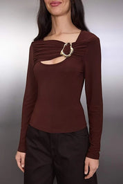Brown long-sleeve top with a decorative cutout detail on a plain background