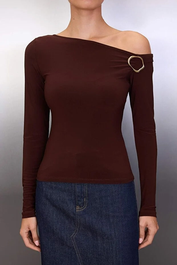 Brown off-shoulder top with a gold buckle detail on a plain background