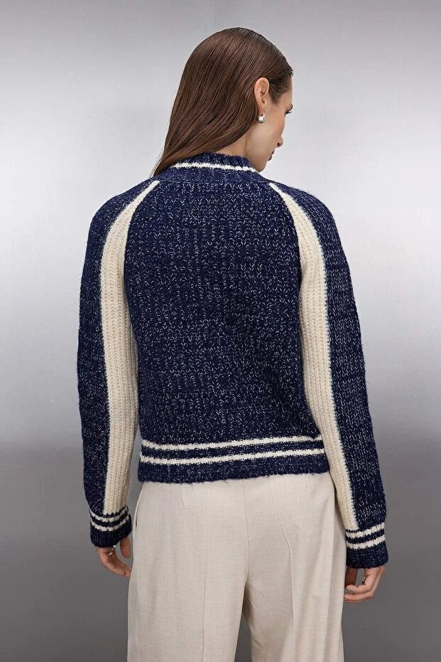 Woman wearing a navy and white striped sweater against a gray background