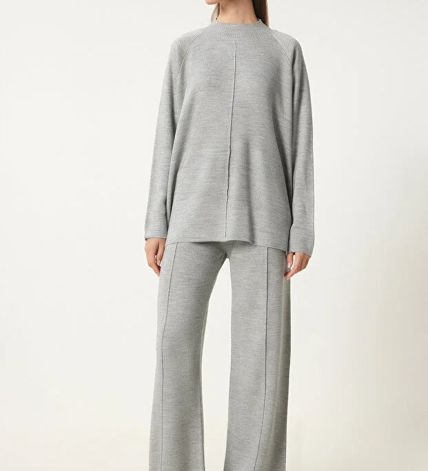 Soft light gray knit lounge set by AtikaStyle. Two-piece outfit featuring ribbed sweater and wide-leg pants — the perfect blend of comfort and minimalist elegance. Made in Turkey.
