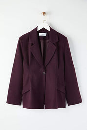 Purple blazer on a hanger against a white background