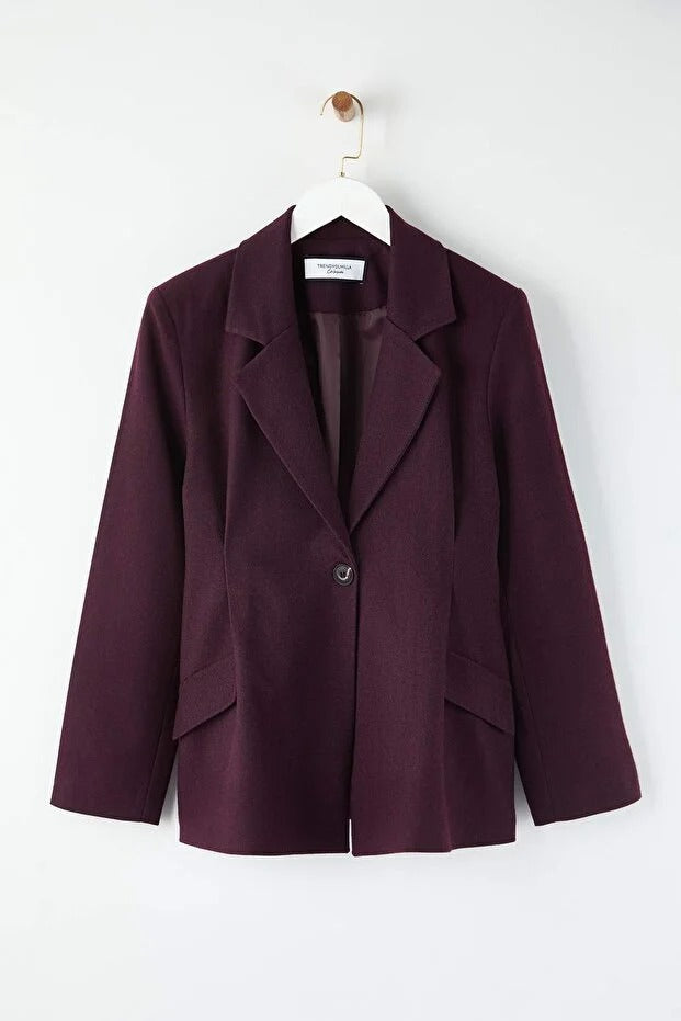 Purple blazer on a hanger against a white background