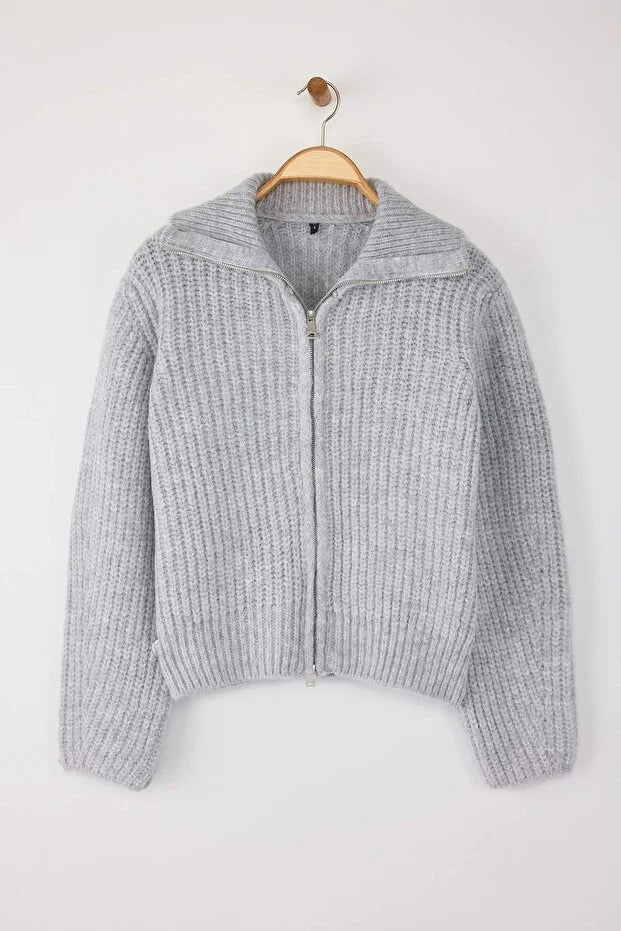 Gray knitted sweater on a wooden hanger against a white background