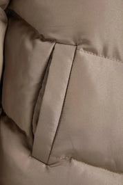 Close-up of beige quilted fabric with a visible seam