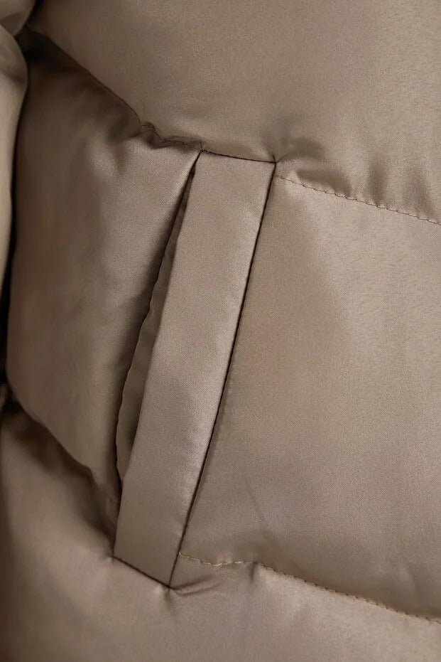 Close-up of beige quilted fabric with a visible seam