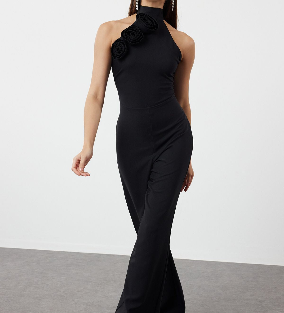 Turn heads with our Elegant Black Halter Jumpsuit featuring a stunning floral detail on the shoulder. Perfect for formal events and evening occasions, this chic and sophisticated jumpsuit offers a flattering fit and timeless style. Shop now for the perfect evening wear!