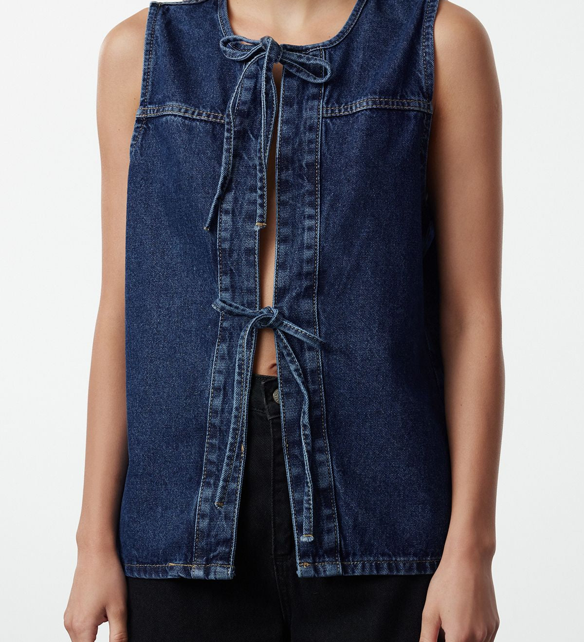 Upgrade your wardrobe with our Classic Denim Vest, the perfect layering piece for any casual outfit. This versatile sleeveless vest features a front tie closure and high-quality denim for a chic and timeless look. Shop now!